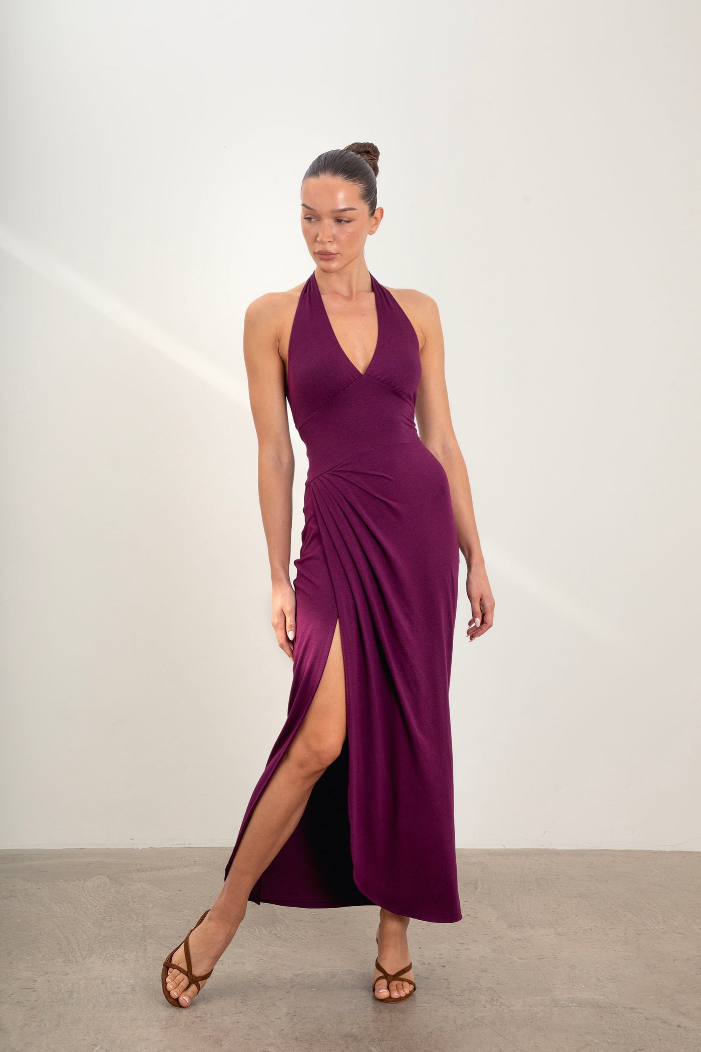 Model wearing Divine Dress halterneck maxi dress in deep plum with sleeksculpt fabric